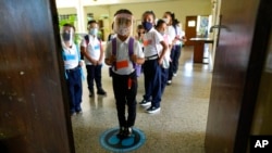 Los estudiantes esperan instrucciones para ingresar a su salón de clases el primer día de regreso a la escuela presencial desde el inicio de las restricciones por el COVID-19, en una escuela pública en Caracas,. Octubre 25, 2021.