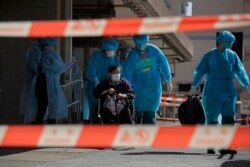 A resident of The Salvation Army Lung Hang Residence for Senior Citizens is evacuated by medical staff from the Centre for Health Protection, after employees of the nursing home were found to have the coronavirus, in Hong Kong.