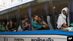 FILE PHOTO - Cambodian migrant workers sit in a bus upon arrival at Cambodia-Thailand's international border gate in Poipet, Cambodia, from Thailand, Tuesday, June 17, 2014.