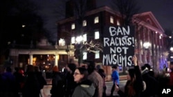 មនុស្ស​រាប់រយ​នាក់​ដើរ​ក្បួន​កាត់​របងHarvard Yard នៅ​ក្នុង​សាកលវិទ្យាល័យ Harvard ខណៈ​ដែល​ធ្វើ​ការ​តវ៉ា​បំរាម​ធ្វើ​ដំណើរ​របស់​លោក នៅ​ក្នុង​ក្រុង Cambridge រដ្ឋMassachusetts កាលពី​ថ្ងៃទី៧ ខែមីនា ឆ្នាំ២០១៧។