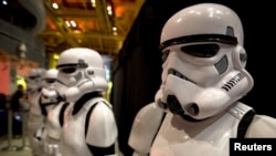 FILE - People dressed as Storm Trooper characters from "Star Wars" await people to purchase toys that are to go on sale at midnight in advance of the film "Star Wars: The Force Awakens" in Times Square in the Manhattan borough of New York.