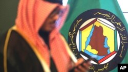 Foto tomada el 5 de diciembre del 2017 de un hombre frente al estandarte del Consejo de Cooperación del Golfo en Kuwait. 