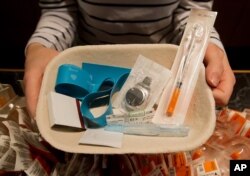FILE - Registered nurse Sammy Mullally holds a tray of supplies to be used by a drug addict at the Insite safe injection clinic in Vancouver, B.C., Canada.