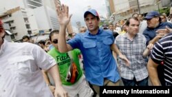 El líder opositor Henrique Capriles saluda a sus seguidores durante la marcha del 1 de mayo en Caracas.
