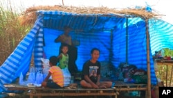 Displaced people from Myanmar live under a makeshift tent along the Thai side of the Moei River in Mae Sot, Thailand on Feb. 7, 2022. 