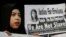 A supporter of Indonesian maid Erwiana Sulistyaningsih, holds a placard as Sulistyaningsih arrives at a court in Hong Kong, Feb. 10, 2015.