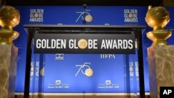 Two Golden Globes statues flank the podium prior to the nominations for 75th annual Golden Globe Awards at the Beverly Hilton hotel in Beverly Hills, Calif., Dec. 11, 2017.
