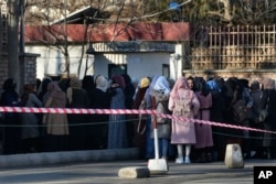 Mahasiswa Afghanistan antre di salah satu gerbang Universitas Kabul di Kabul, Afghanistan, pada 26 Februari 2022. (Foto: AP)
