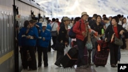 Tourists file out of a passenger train that arrived at the train station in Lhasa