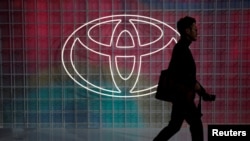 Un hombre pasa por delante del logotipo de Toyota en Tokio, Japón. [Foto de archivo]