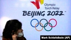 一名女性在北京郵電大學內的北京冬奧廣告前（2021年12月9日）