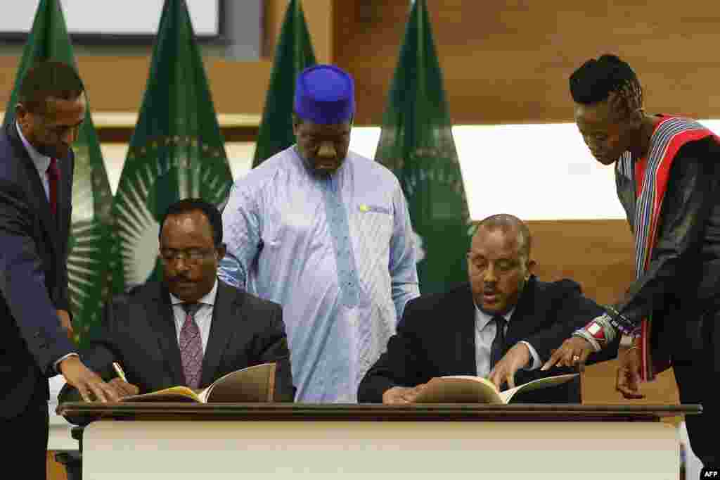Redwan Hussien Rameto, 2nd left, representative of the Ethiopian government, and Getachew Reda, 2nd right, representative of the Tigray People's Liberation Front (TPLF), sign a peace agreement between the two parties during a press conference regarding the African Union-led negotiations to resolve conflict in Ethiopia at the Department of International Relations and Cooperation offices in Pretoria, South Africa.