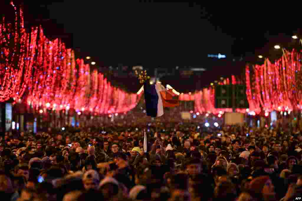 People gather in the Champs-Elysees as the French capital Paris gears up for New Year's Celebrations, Dec. 31, 2018.