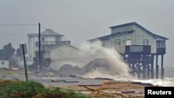 Waves crash on stilt houses along the shore as Hurricane Michael's power is unleashed in Alligator Point, Franklin County, Fla., Oct. 10, 2018.
