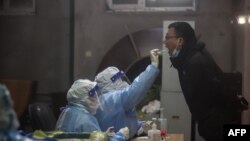 A resident undergoes a nucleic acid test for COVID-19, in Changchun in China's northeastern Jilin province, March 11, 2022. 