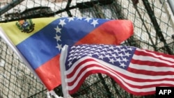 ARCHIVO - Un hombre sostiene banderas de Venezuela y Estados Unidos durante un acto político en Nueva York, el 17 de noviembre de 2006.