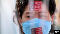 រូបឯកសារ៖ អតីតបុគ្គលិកក្រុមហ៊ុនណាហ្គាវើលដ៍ចូលរួមទិវាសិទ្ធិនារីអន្តរជាតិ ដោយទាមទារឲ្យមានការដោះលែងសហជីពដែលត្រូវបានឃុំខ្លួន នៅមុខមន្ទីរឃុំឃាំងព្រៃស រាជធានីភ្នំពេញ ថ្ងៃទី ៨ ខែមីនា ឆ្នាំ ២០២២។ (AFP)