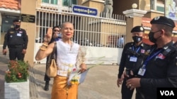 កញ្ញា សេង ធារី លើក​ម្រាមដៃ​៣ មុន​ចូលបន្ទប់​សវនាការ​នៅ​តុលការ​ក្រុង​ភ្នំពេញ នៅ​រាជធានី​ភ្នំពេញ នៅ​ថ្ងៃទី២៨ ខែមីនា ឆ្នាំ២០២២។ (លាស់ លីបលីប/វីអូអេ)