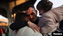 ជនភៀសខ្លួន​ម្នាក់​លា​ប្រពន្ធ​និងកូនស្រី​របស់​គាត់ មុន​នឹង​ពួកគេ​ឡើង​រថភ្លើង​ទៅ​កាន់​ទីក្រុង Budapest ដើម្បី​ភៀសខ្លួន​ពី​ការ​ឈ្លានពាន​របស់​រុស្ស៊ី​មក​លើ​អ៊ុយក្រែន នៅ​ទីក្រុង Bucharest ប្រទេស​រ៉ូម៉ានី ថ្ងៃទី១៤ ខែមីនា ឆ្នាំ២០២២។