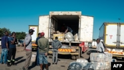 Mwanaume aonekana nyuma ya gari ya mazigo ambayo imewasili mjini Harare kutoka Afrika Kusini, ikibeba chakula, March 22, 2022. Picha ya AFP