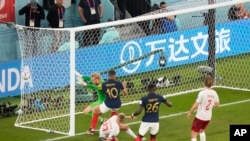 France's Kylian Mbappe, second left, sends his second goal past Denmark's goalkeeper Kasper Schmeichel, right, during the World Cup group D soccer match between France and Denmark, at the Stadium 974 in Doha, Qatar, Saturday.
