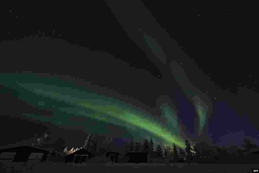 Northern lights (aurora borealis) illuminate the sky over Jukkasjarvi, near Kiruna, in Swedish Lapland, Nov. 20, 2022. 