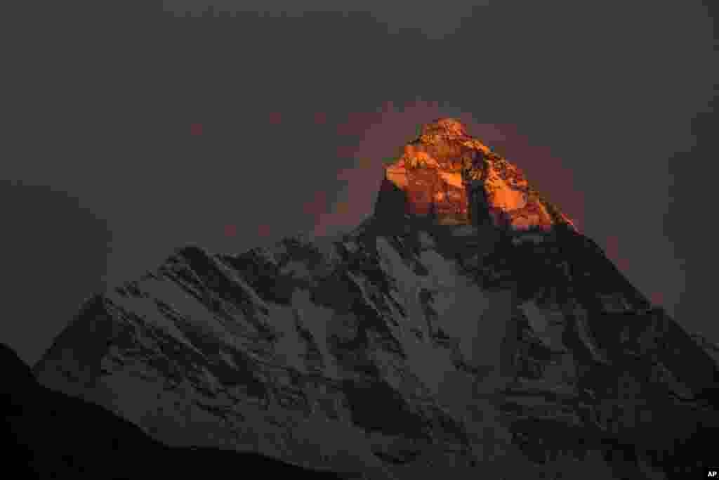 Rays of the setting sun falls on the Nanda Devi mountain peak in Auli, Uttarakhand state, India.