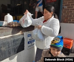 A woman and her son at Food for Others in Fairfax, Virginia, Nov. 16, 2022. The center, just outside Washington, is providing Thanksgiving provisions and a gift card to buy turkey or additional food items.