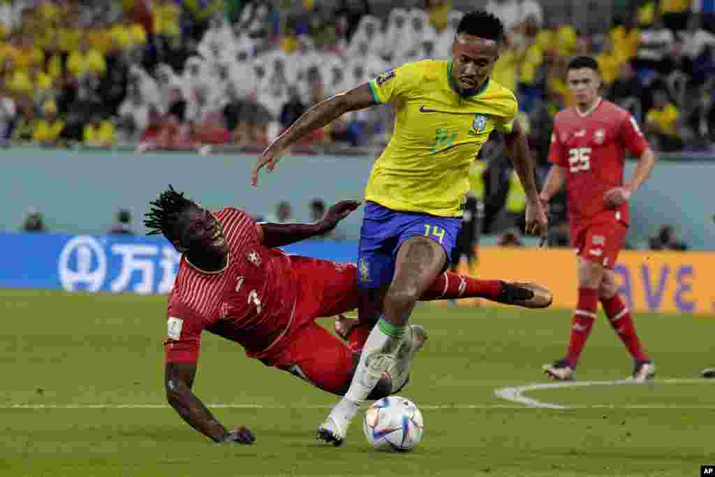 Switzerland's Breel Embolo, left, and Brazil's Eder Militao vie for the ball during the World Cup group G soccer match between Brazil and Switzerland, at the Stadium 974 in Doha, Qatar.