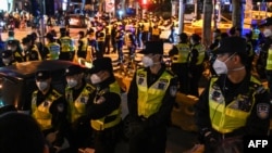 Police officers block Wulumuqi street, named for Urumqi in Mandarin, in Shanghai on Nov. 27, 2022, in the area where protests against China's zero-COVID policy took place the night before following a deadly fire in Urumqi.