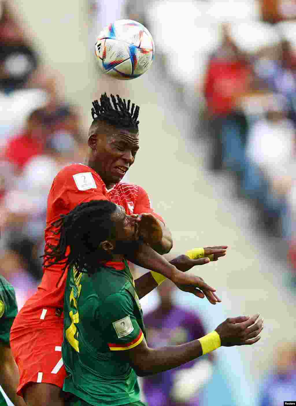 Switzerland's Breel Embolo jumps for a header with Cameroon's Andre-Frank Zambo Anguissa during the World Cup group G soccer match between Switzerland and Cameroon at the Al Janoub Stadium in Al Wakrah, Qatar.