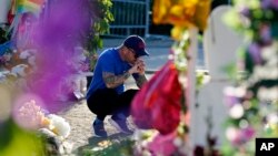 A man pays his respects at a memorial outside Robb Elementary School, June 2, 2022, in Uvalde, Texas, to honor the victims killed in the May 24, 2022, school shooting. 
