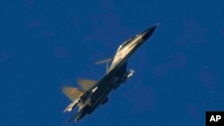A Chinese J-11 military fighter jet flies above the Taiwan Strait near Pingtan, the closest land of mainland China to the island of Taiwan, in Pingtan in southeastern China's Fujian Province, Aug. 5, 2022.