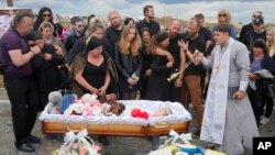 Relatives and friends attend the funeral service for Liza, a four-year-old girl killed by a Russian missile, in Vinnytsia, Ukraine, July 17, 2022.