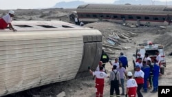 Rescuers work at the scene where a passenger train partially derailed near the desert city of Tabas in eastern Iran, June 8, 2022.