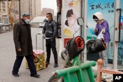 戴著口罩的民眾在新疆街頭。新疆伊犁自治州伊寧縣的民眾表示，在因為新冠病毒而封控40多天後，他們正在經歷飢餓和強迫隔離 (資料圖片)