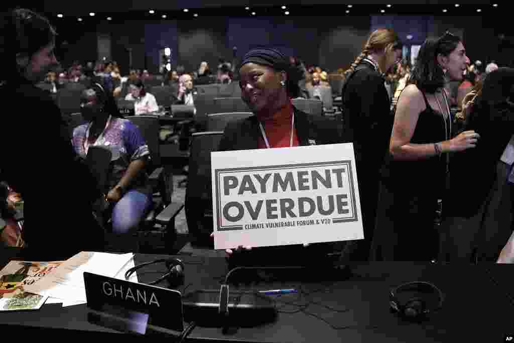 Nakeeyat Dramani Sam, of Ghana, holds a sign that reads "payment overdue" at the COP27 U.N. Climate Summit, in Sharm el-Sheikh, Egypt. She made a plea for negotiators at the summit to come to an agreement that could help curb global warming.