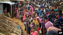 FILE - Rohingya Muslims, who fled Myanmar, wait in queues to receive aid at Kutupalong refugee camp in Ukhiya, Bangladesh, Nov. 15, 2017. 