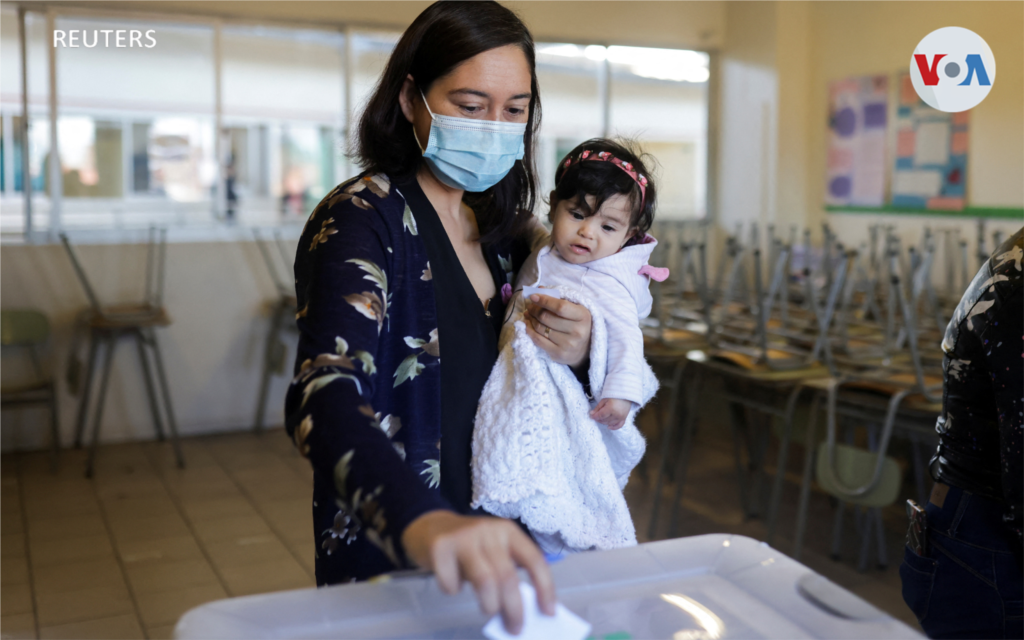 Una mujer con su bebé emite un voto en un colegio electoral en Santiago, Chile.