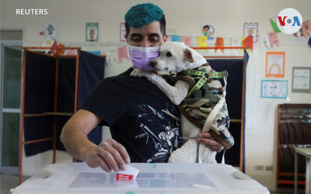 Una persona sostiene a su perro mientras vota en Santiago, Chile.