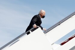 拜登總統在登上“空軍一號”專機前往佐治亞州時在舷梯上跌倒後扶住欄杆。 (2021年3月19日)
