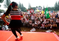 Seorang penyanyi tampil di depan pendukung calon presiden Indonesia Jusuf Kalla dan pasangannya Wiranto, dalam rapat umum kampanye pemilu di Jakarta, 2 Juli 2009. (Foto: REUTERS/Dadang Tri)