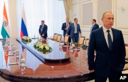 Russian President Vladimir Putin, right, stands before a meeting with Indian Prime Minister Narendra Modi on the sidelines of the Shanghai Cooperation Organization summit in Tashkent, Uzbekistan, June 24, 2016.