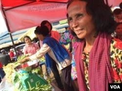 អ្នកស្រី​ តន់​ ស៊ន (ស្តាំ) កំពុង​ឈរ​រង់​ចាំ​អតិថិជន​នៅ​ក្នុង​ផ្សារណាត់​លក់​បន្លែ​សរីរាង្គ ស្ថិត​ក្នុង​ក្រុង​ច្បារមន ខេត្ត​កំពង់ស្ពឺ។ (ដោយ​ ហ៊ុល​ រស្មី/VOA)