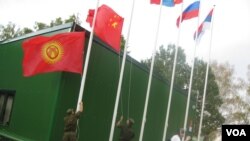 中亞國家經常與中國和俄羅斯共同參加一些活動。 2014年在莫斯科郊外的軍事比賽活動中，俄羅斯軍人升中國和吉爾吉斯國旗。 （美國之音白樺拍攝）