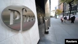 A person walks past the Pfizer Headquarters building in the Manhattan borough of New York City, New York, U.S., November 9, 2020. REUTERS/Carlo Allegri