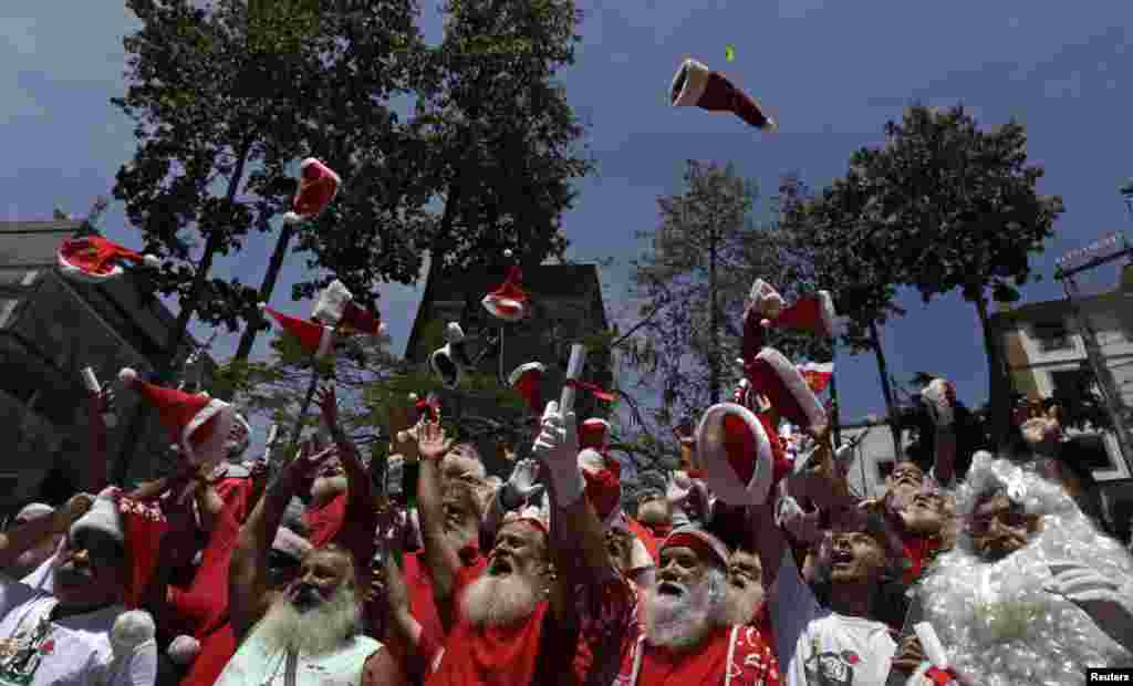 Students from the Brazilian Santa Claus school throw their hats into the air, during their graduation ceremony in Rio de Janeiro. The school holds four-day lessons in Santa-training, teaching Christmas carols, how to interact with children, and also how to wear the heavy red suit in Rio's typical 104-degree (40 degrees celsius) summer weather.