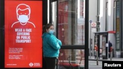 រូបឯកសារ៖ ស្ត្រីម្នាក់ពាក់ម៉ាស់ឈរចាំរថយន្តក្រុង នៅទីក្រុងឡុងដ៍ ចក្រភពអង់គ្លេស កាលពីថ្ងៃទី១៨ ខែឧសភា ឆ្នាំ២០២០។