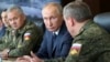 FILE - Russian President Vladimir Putin, center, and Russian Defense Minister Sergei Shoigu, left, attend the main stage of the Kavkaz-2020 strategic command-and-staff exercises at the Kapustin Yar training ground, Russia, Sept. 25, 2020.