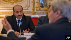 FILE - Syrian National Coalition Chief Ahmad al-Jarba, left, listens to US Secretary of State John Kerry, right, during the start of their meeting at the US Ambassador residence in Paris, France, Monday, Jan. 13, 2014.